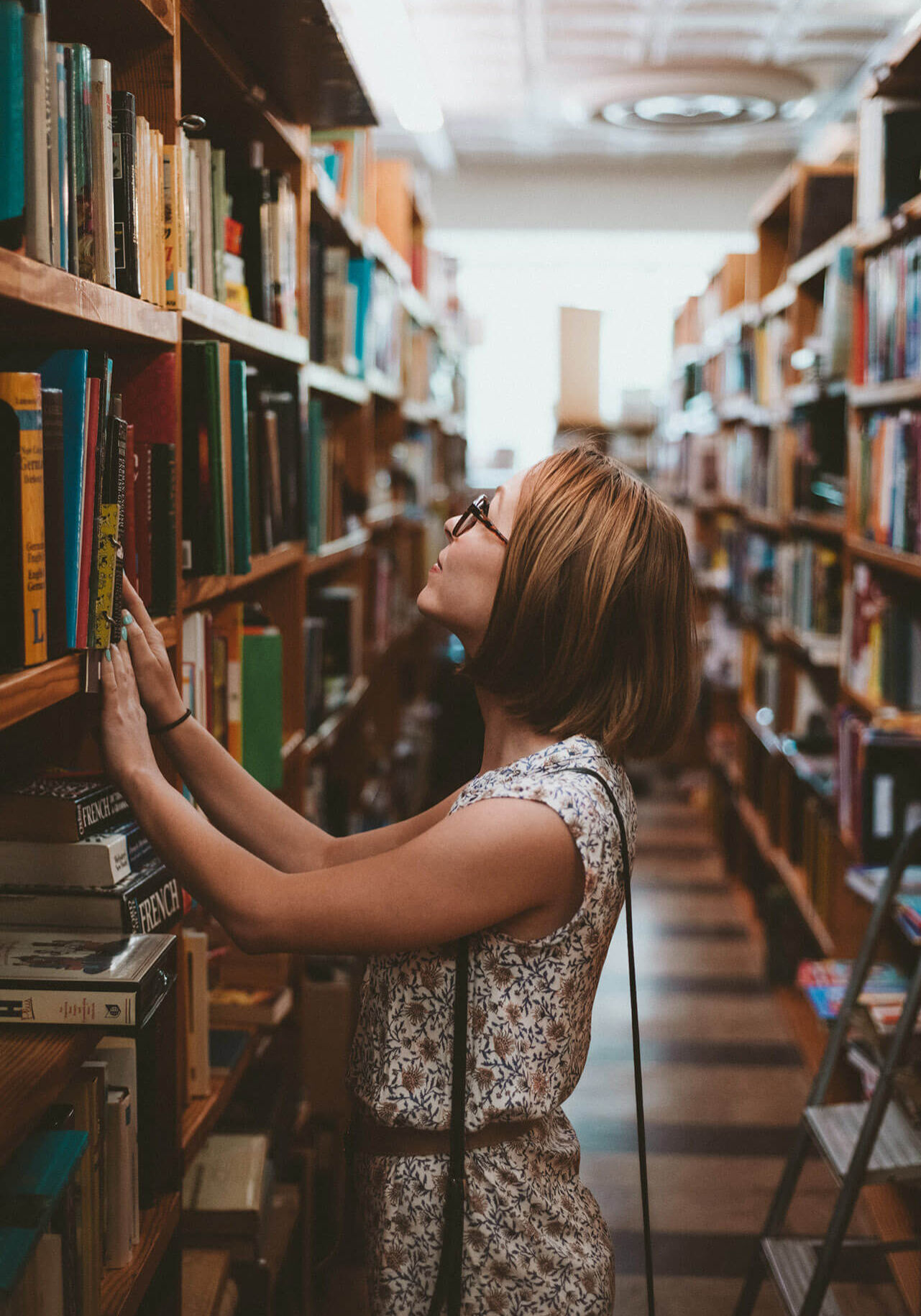 woman looking at bookshelves in a library